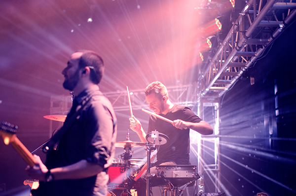 Shot of the guitarist and drummer under stage lights